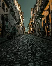 A couple sits on rocks by a serene lake