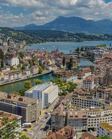 A scenic city skyline featuring a river flowing beneath a bridge
