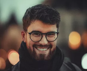 A smiling man with glasses and a beard