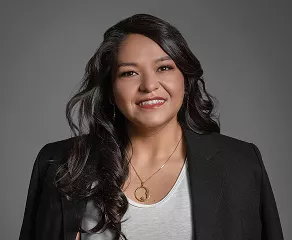 A woman wearing a black blazer over a white shirt