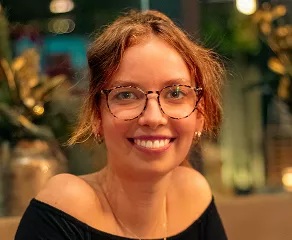 A woman wearing glasses and a black top is seated at a table