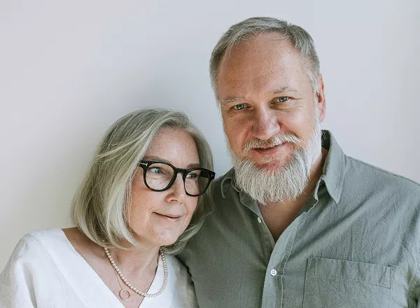A man and woman smile warmly at the camera