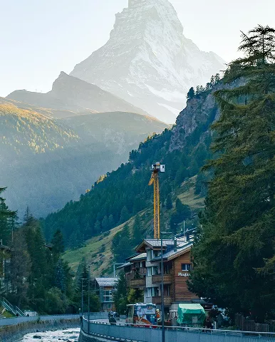 A scenic mountain range with a flowing river in the foreground